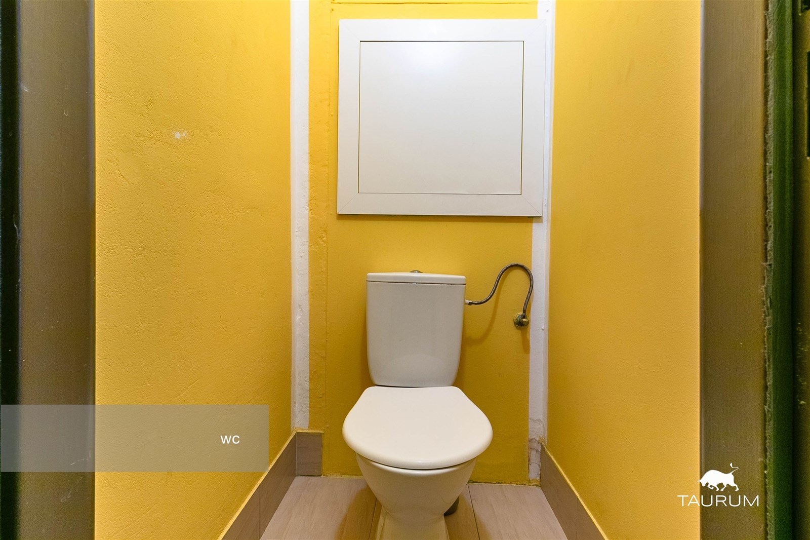 Malá toaleta s dřevěnou podlahou, žluté stěny pro 