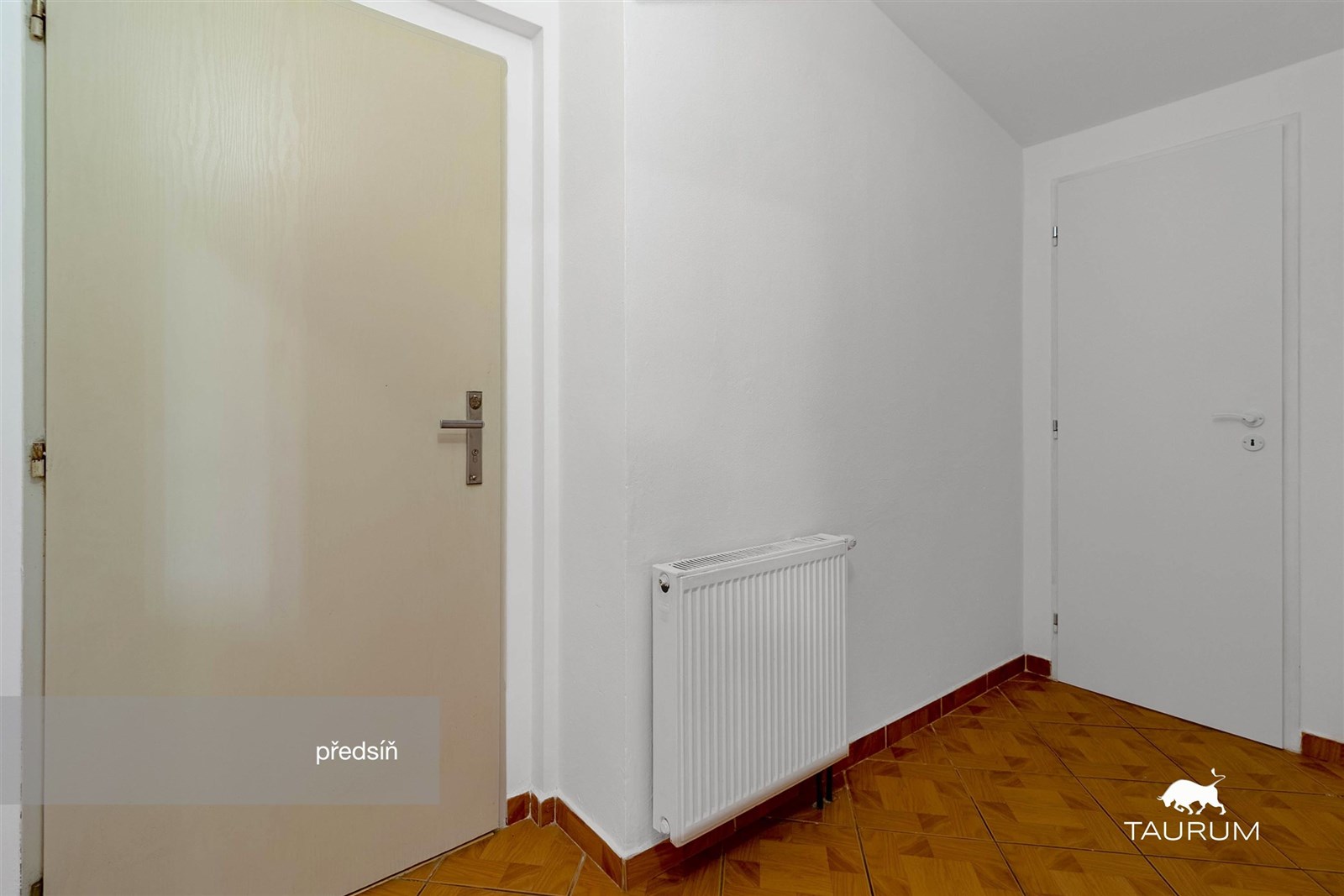 Vstupní předsíň s dlažbou a bílými stěnami, vybave