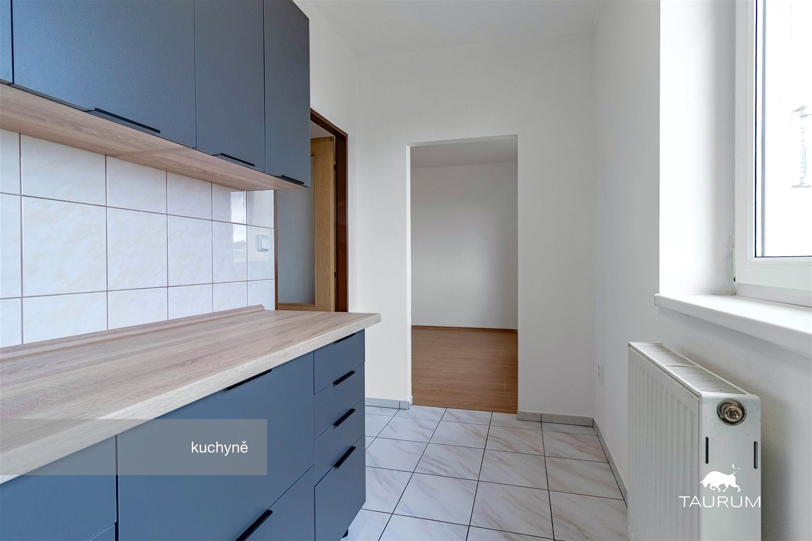 Moderní kuchyň s dlažbou, tmavými skříňkami a svět