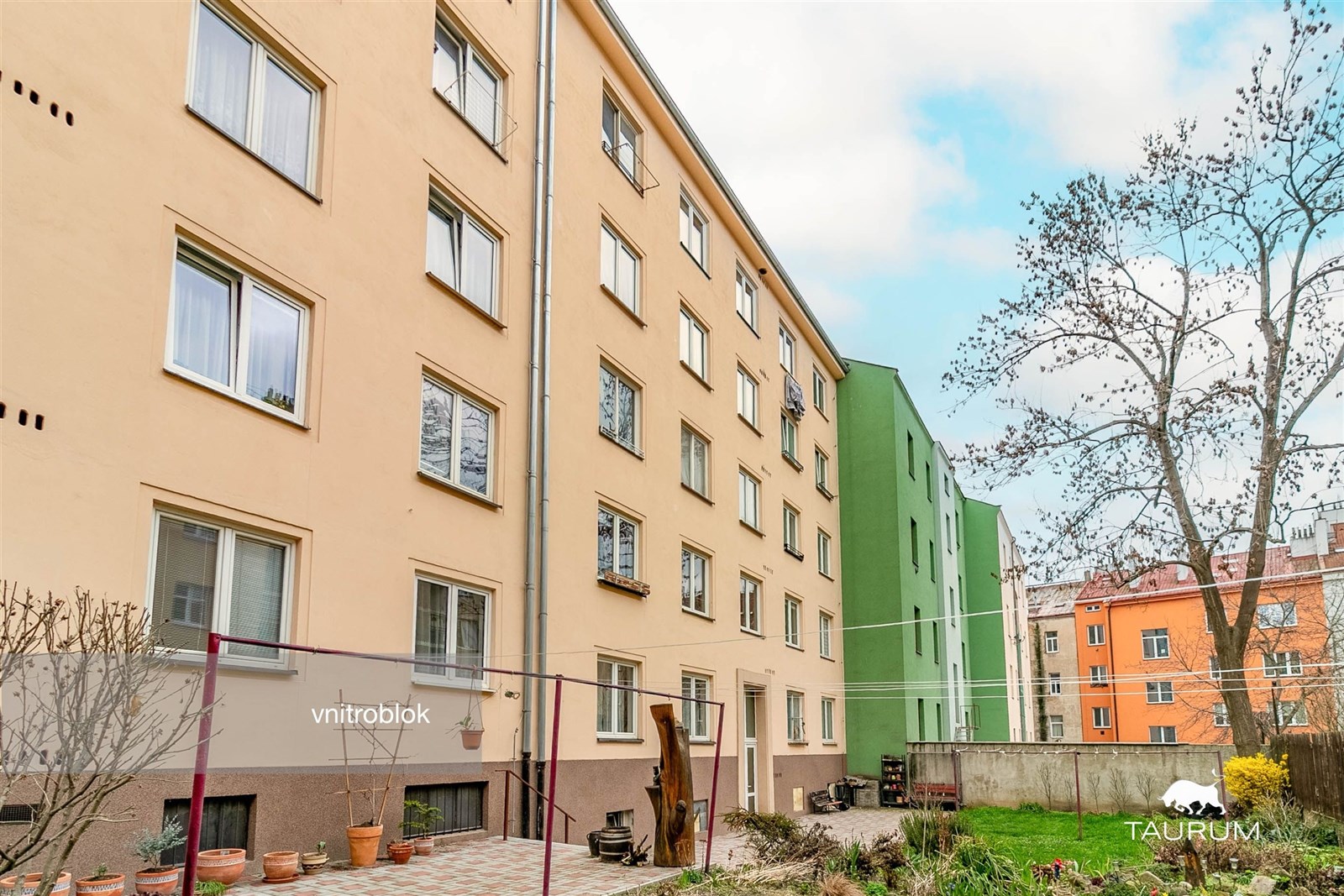 Vnitroblok bytového domu s upravenou zahradou, dlá