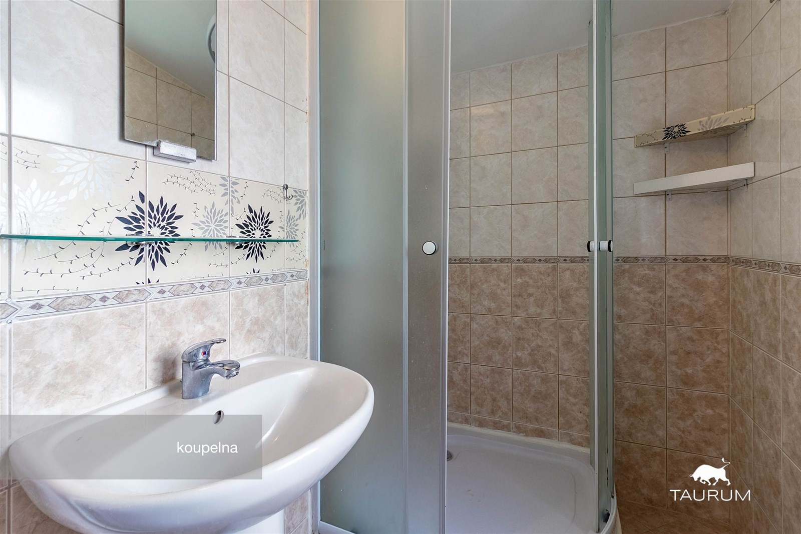 Malá koupelna s keramickými obklady, sprchovým kou