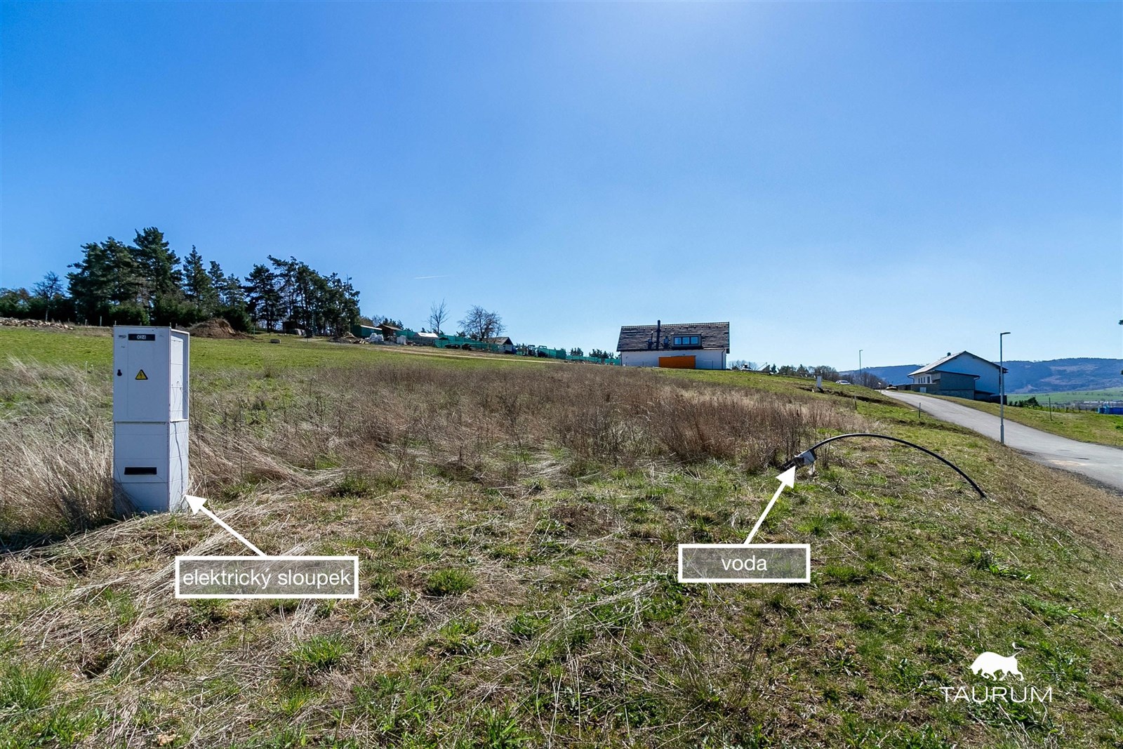 Stavební pozemek s elektrickým sloupkem a přívodem vody, mírně svažitý terén, vhodný pro výstavbu rodinného domu, klidná lokalita na okraji města