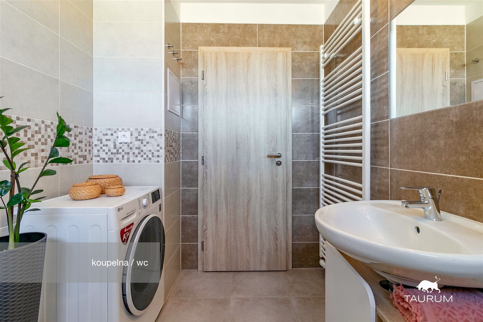 Moderní koupelna s dlažbou, elegantním obkladem a pračkou, světlý interiér s designovým umyvadlem a topným žebříkem je ideálním řešením pro rodinu