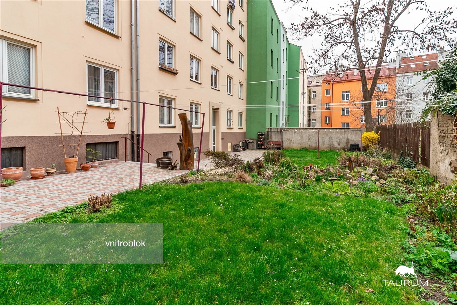 Udržovaný vnitroblok s trávníkem a dlažbou, obklop