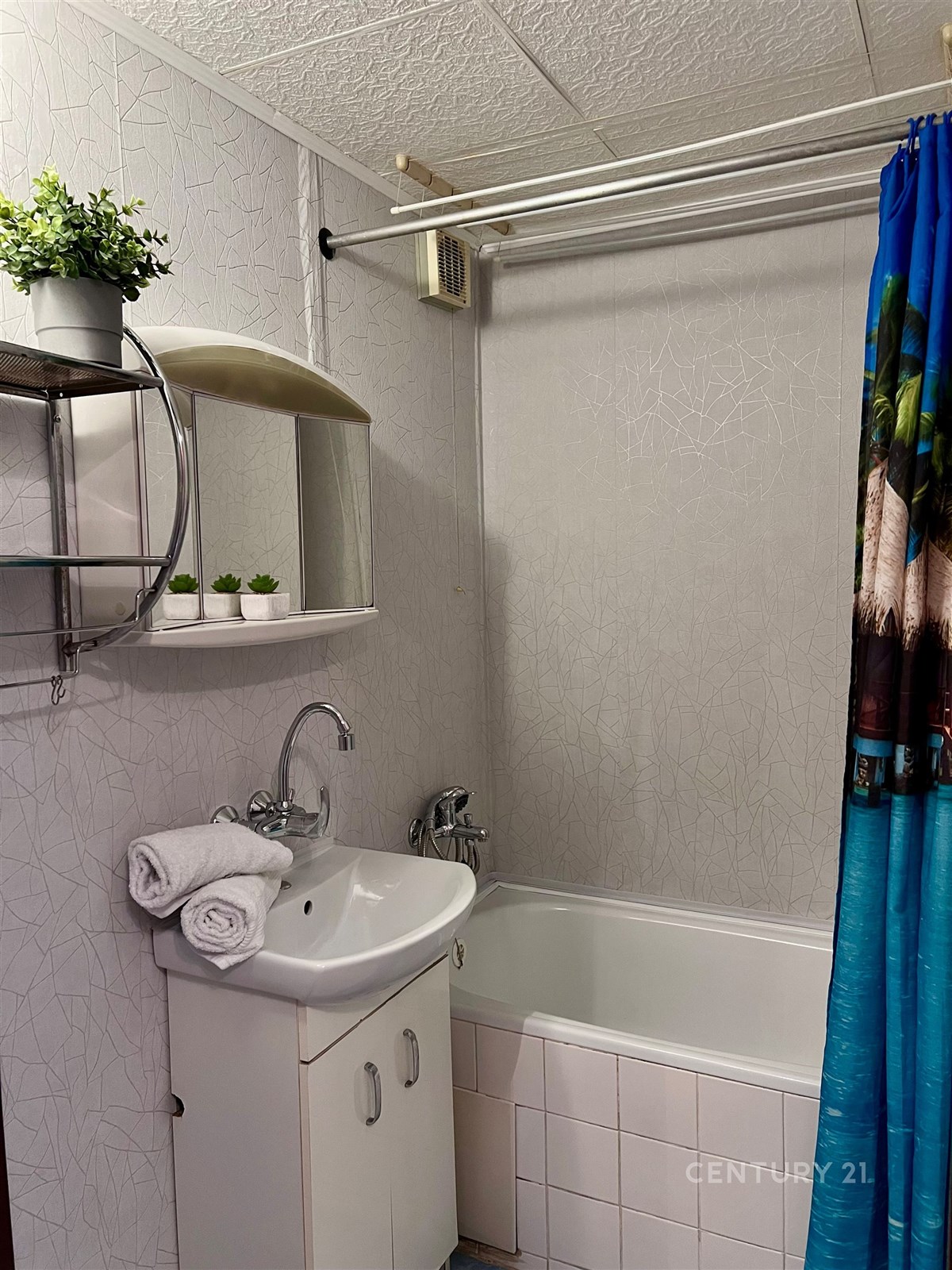 Kompaktní koupelna s vanou, dlažbou a moderním umy