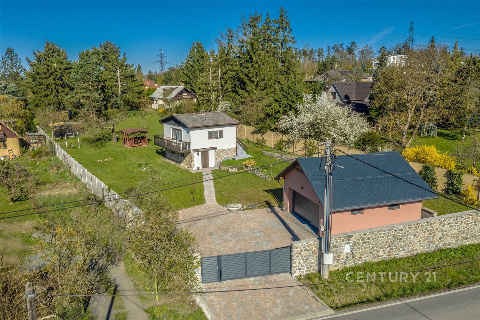 Rodinný dům s velkou zahradou, obklopený stromy. D