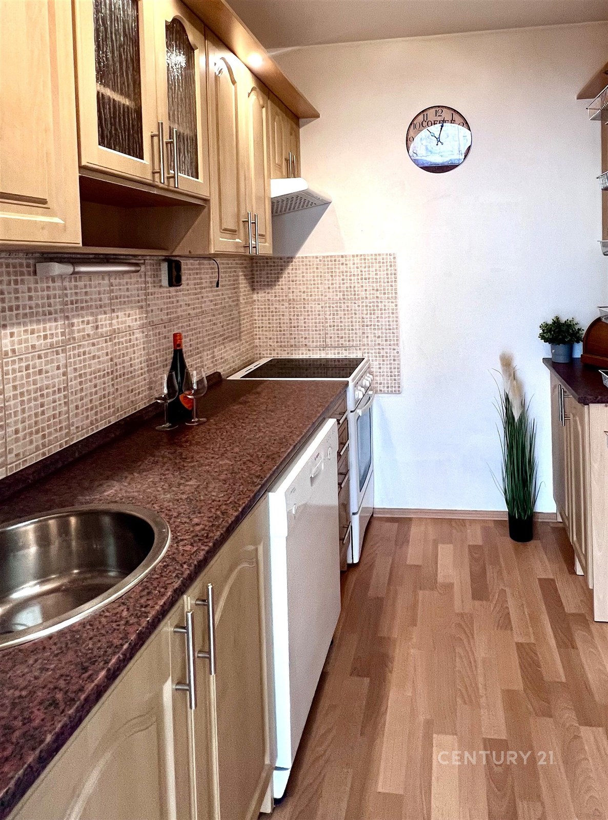 Úzká kuchyň s dřevěnými skříňkami, moderními spotř