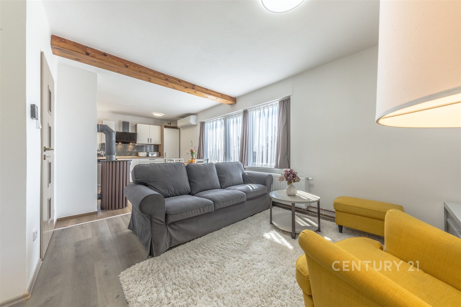 Světlý obývací pokoj s dřevěnými trámy, moderní ku