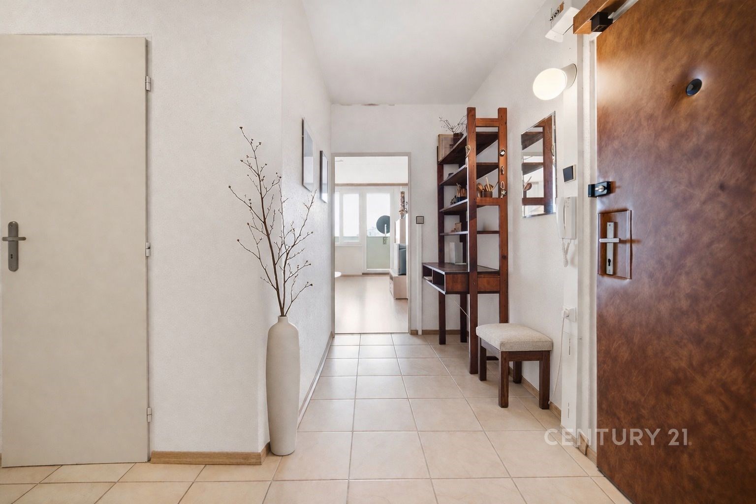 Vstupní chodba s dlažbou, dřevěným nábytkem a mode