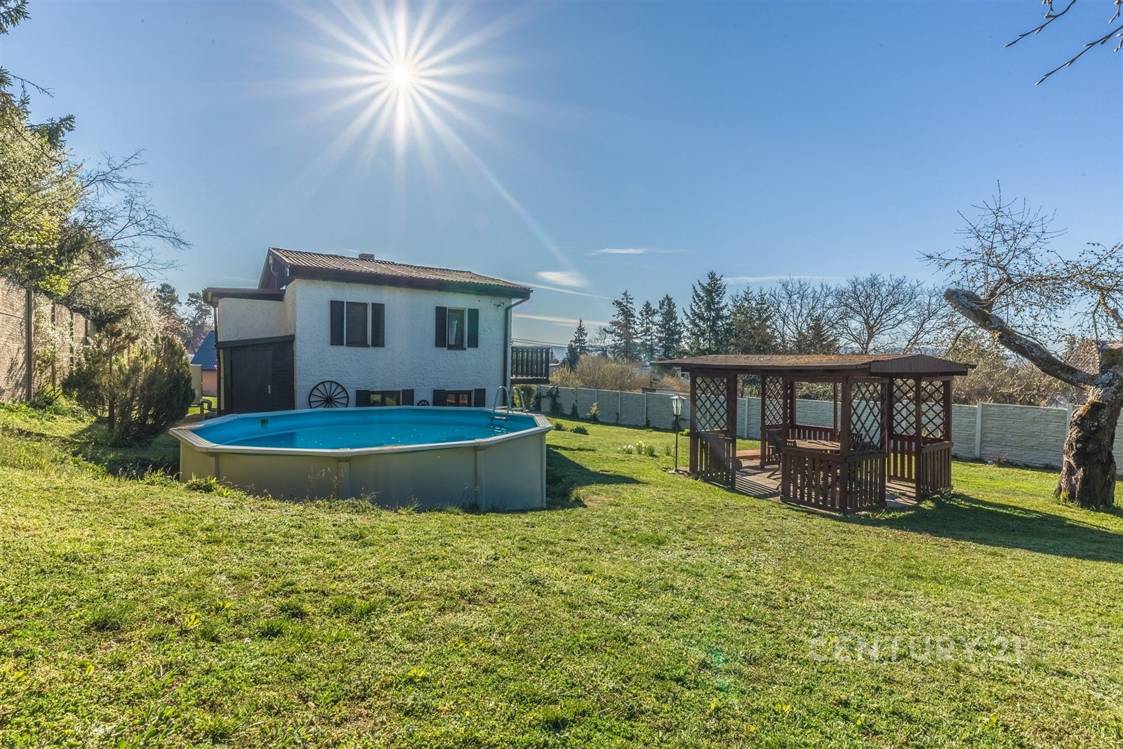 Zahradní prostor s moderním bazénem a dřevěnou per