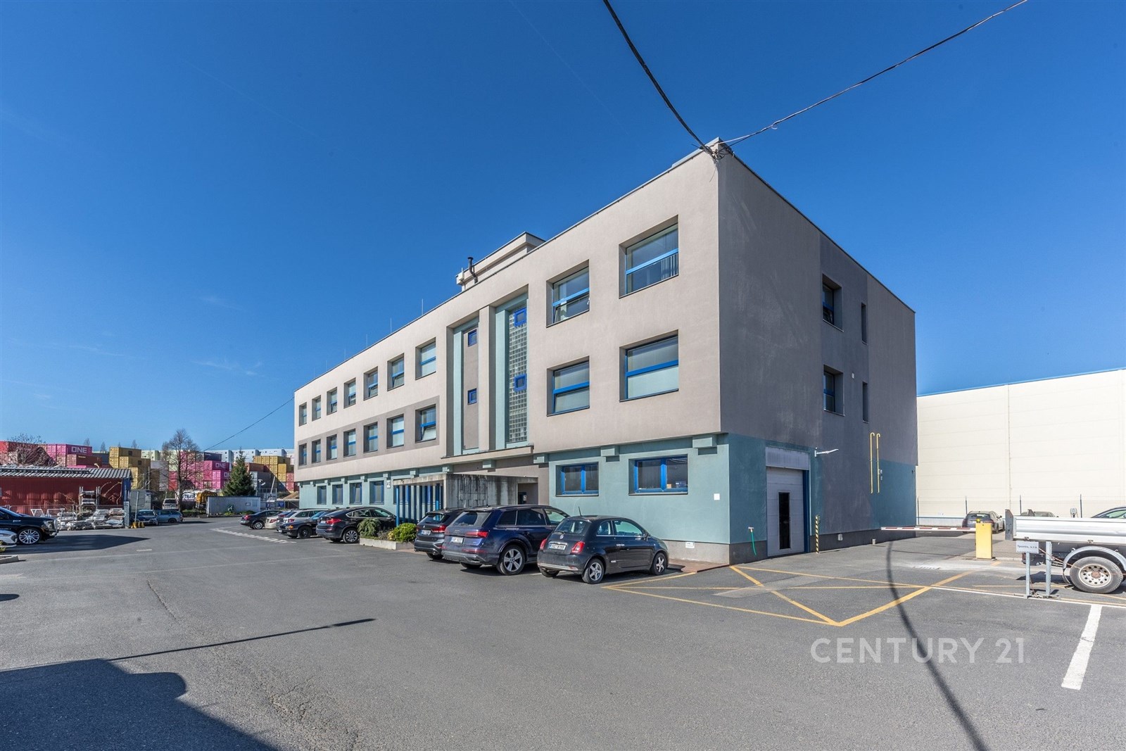 Moderní komerční budova s velkými okny a parkovací