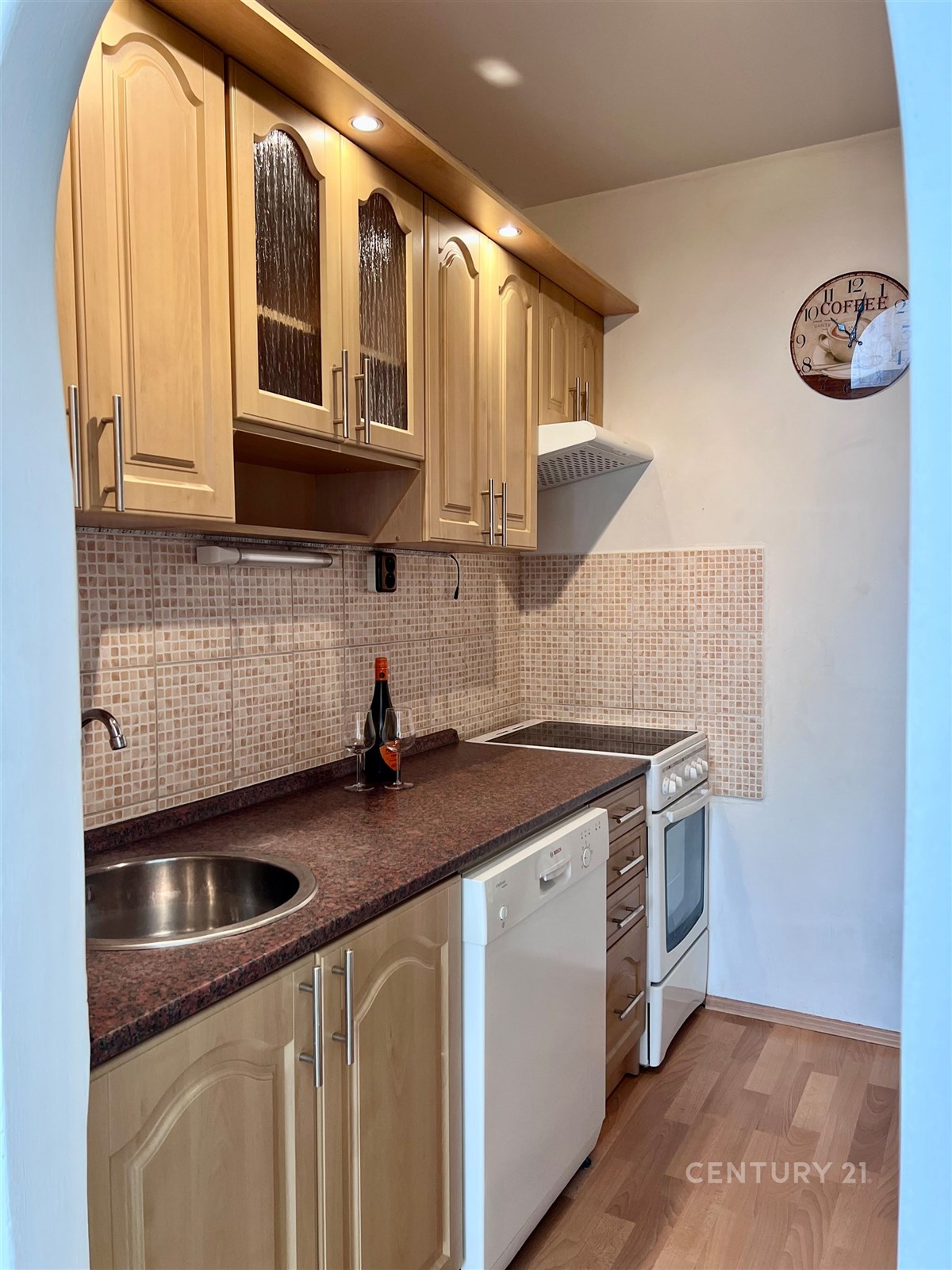 Kompaktní kuchyň s dřevěnými skříňkami, moderními 