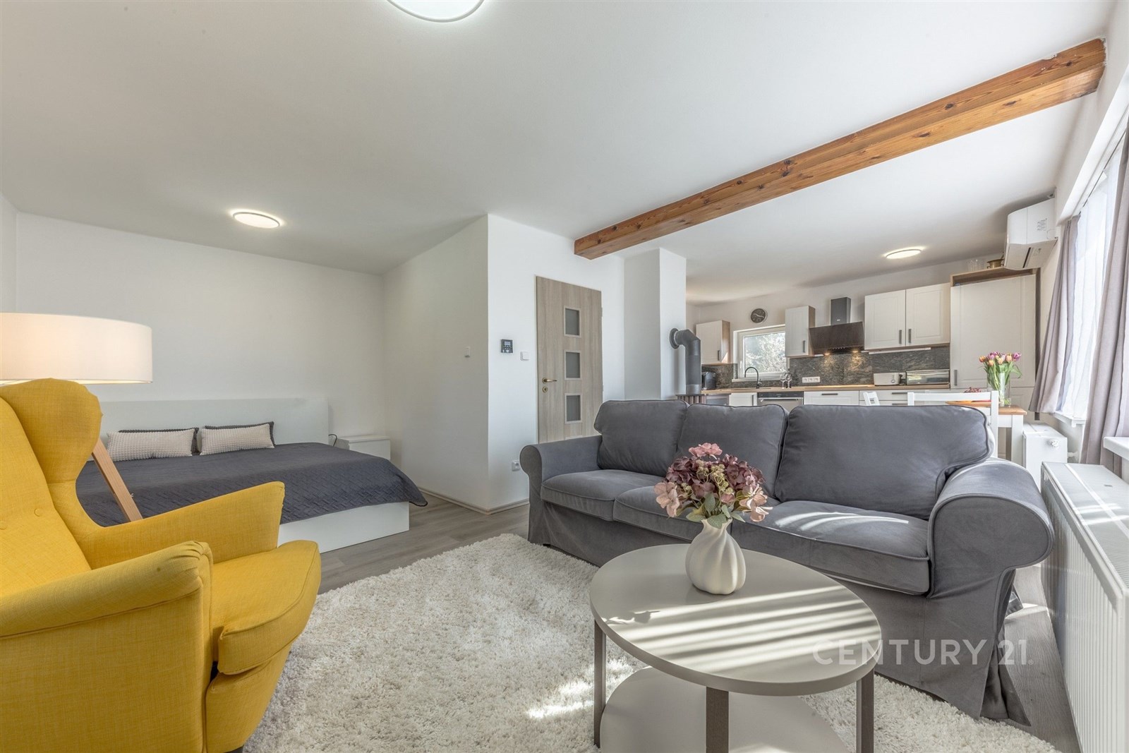 Světlý obývací pokoj s parketovou podlahou a velký