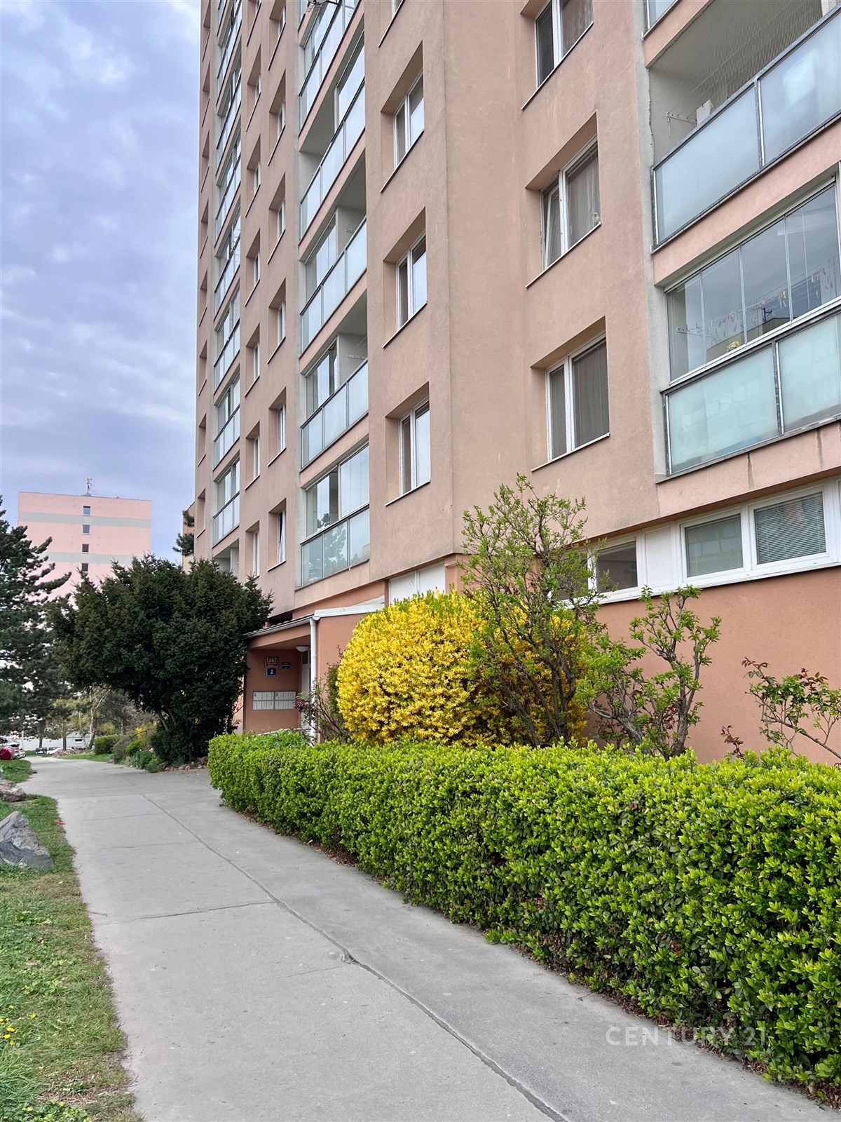 Venkovní pohled na bytový dům s moderní fasádou. V