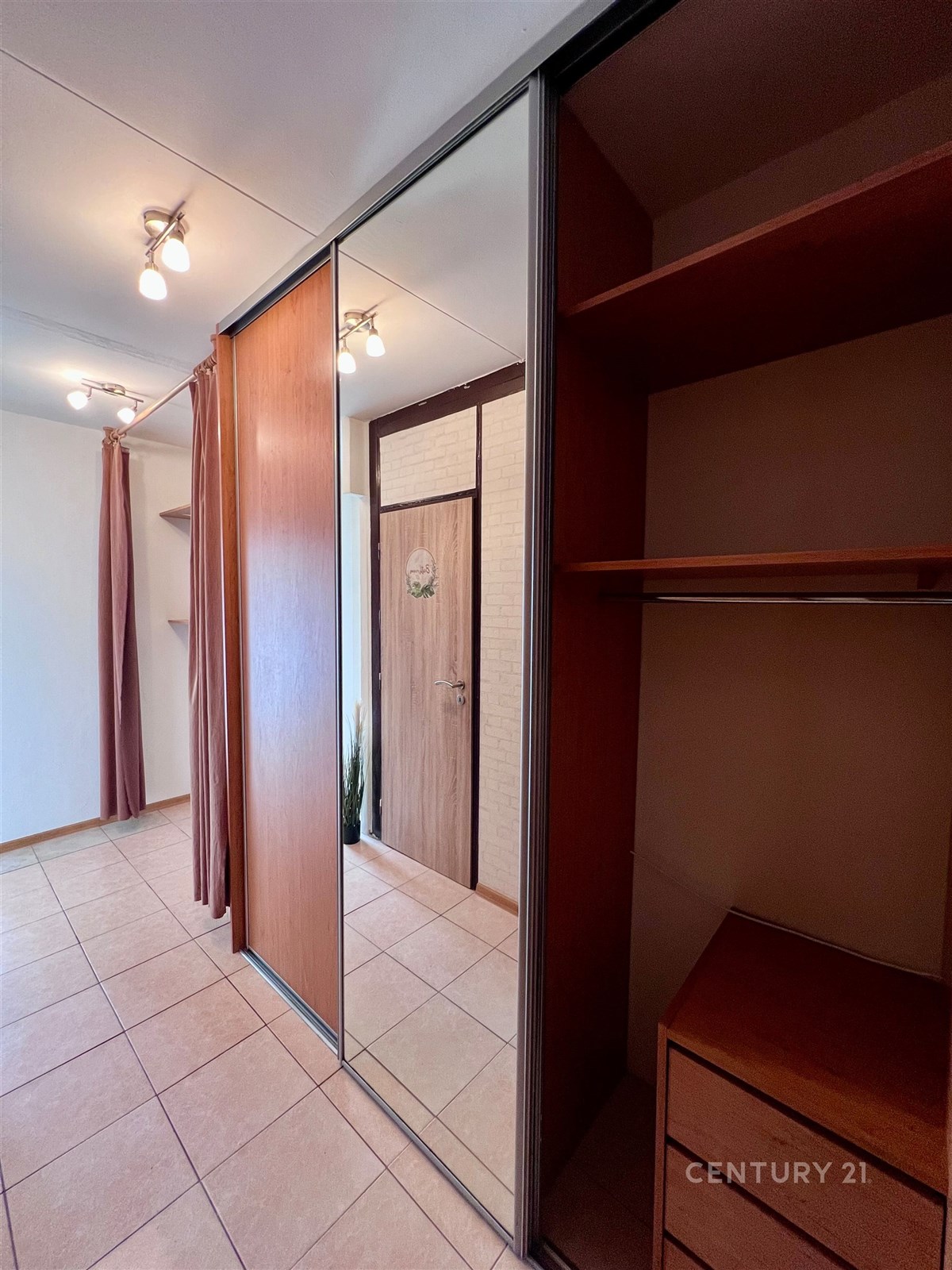 Prostorná chodba s dlažbou, vestavěnými skříněmi a