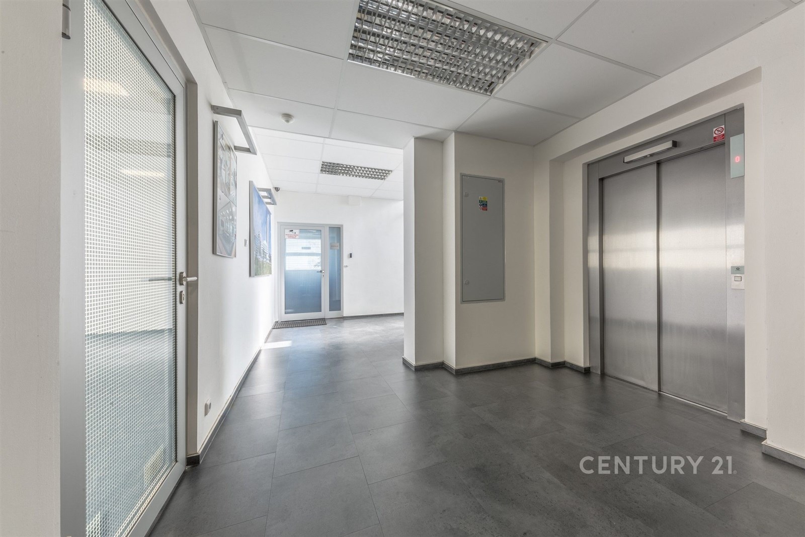 Světlá vstupní hala s dlažbou, moderní výtah a pro
