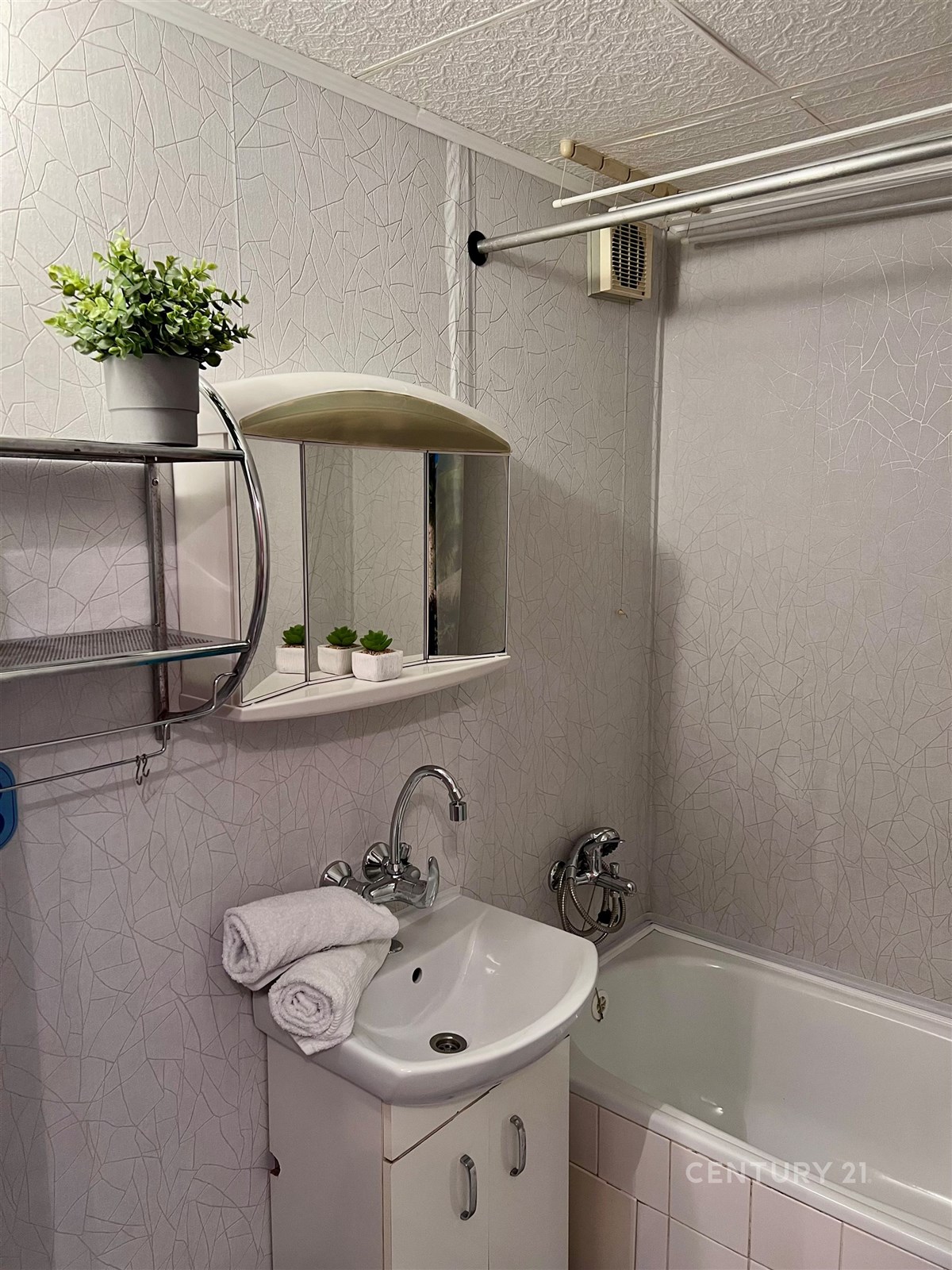 Kompaktní koupelna s bílými obklady, vanou a moder