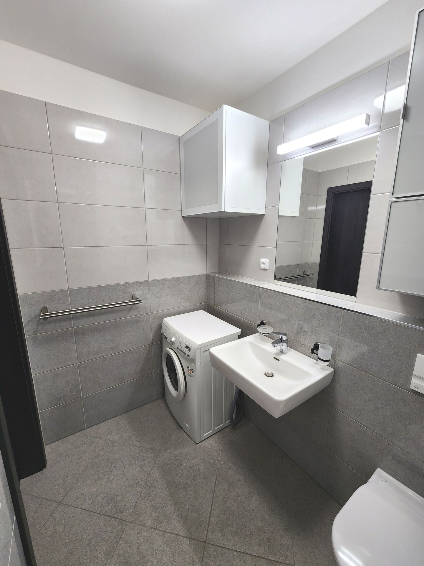 Umyvadlo a pračka v koupelně