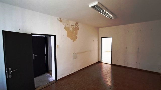 Prázdná místnost s dlažbou na podlaze, bílými stěn