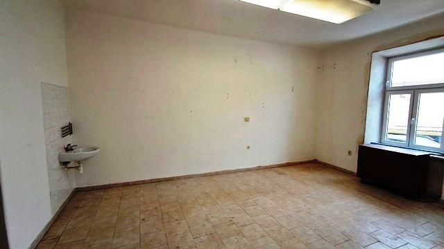 Prázdná místnost s dlažbou, velkým oknem a přiroze