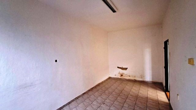 Prázdná místnost s bílými stěnami, dlažbou na podl