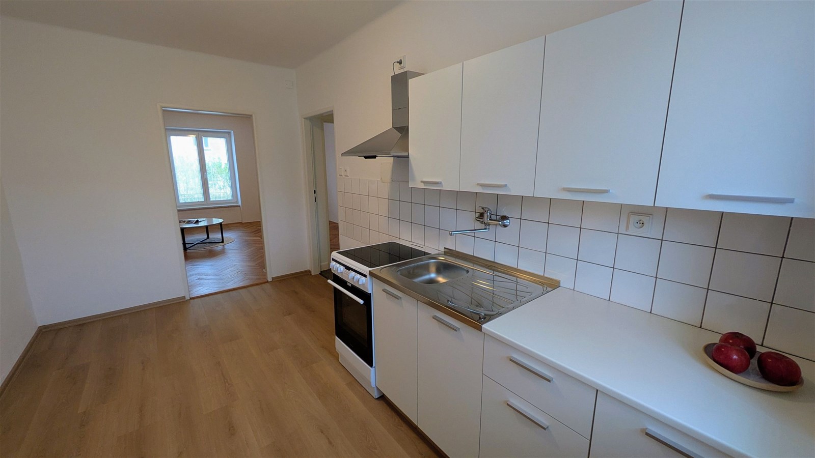 Moderní kuchyň s parketovou podlahou, bílými skříň