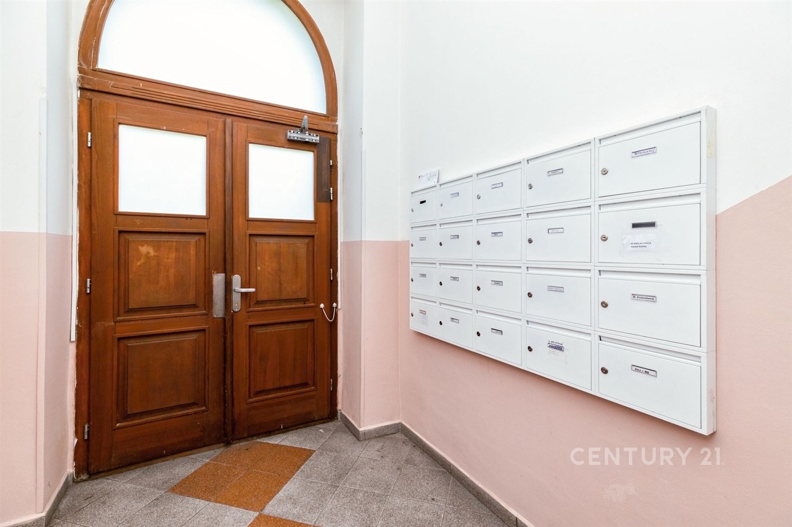 Vstupní chodba s dřevěnými dveřmi, dlažbou a pošto