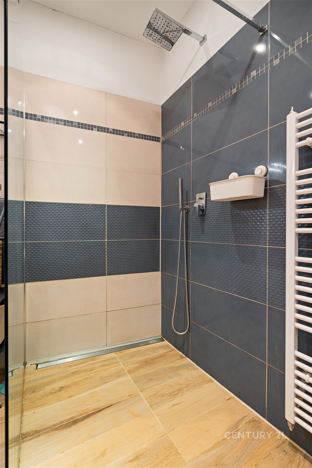 Moderní koupelna s dlažbou a parketovou podlahou, vybavená sprchovým koutem a topným žebříkem, navržena v elegantním stylu.