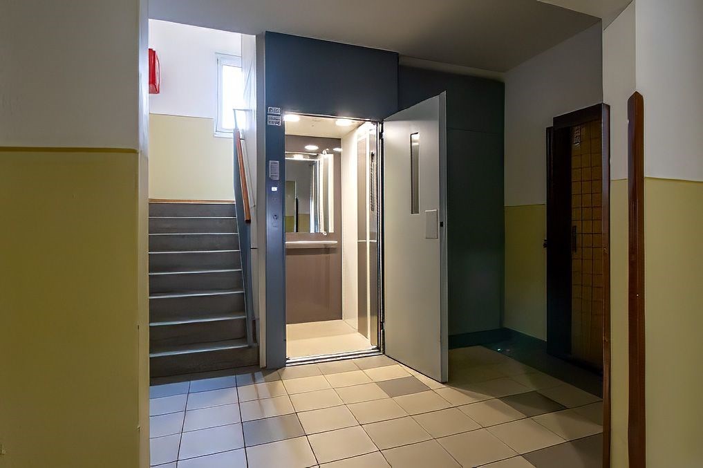 Vstupní hala s moderním výtahem, dlažba a schodišt