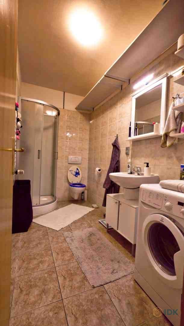 Koupelna s dlažbou a sprchovým koutem, obsahuje zr