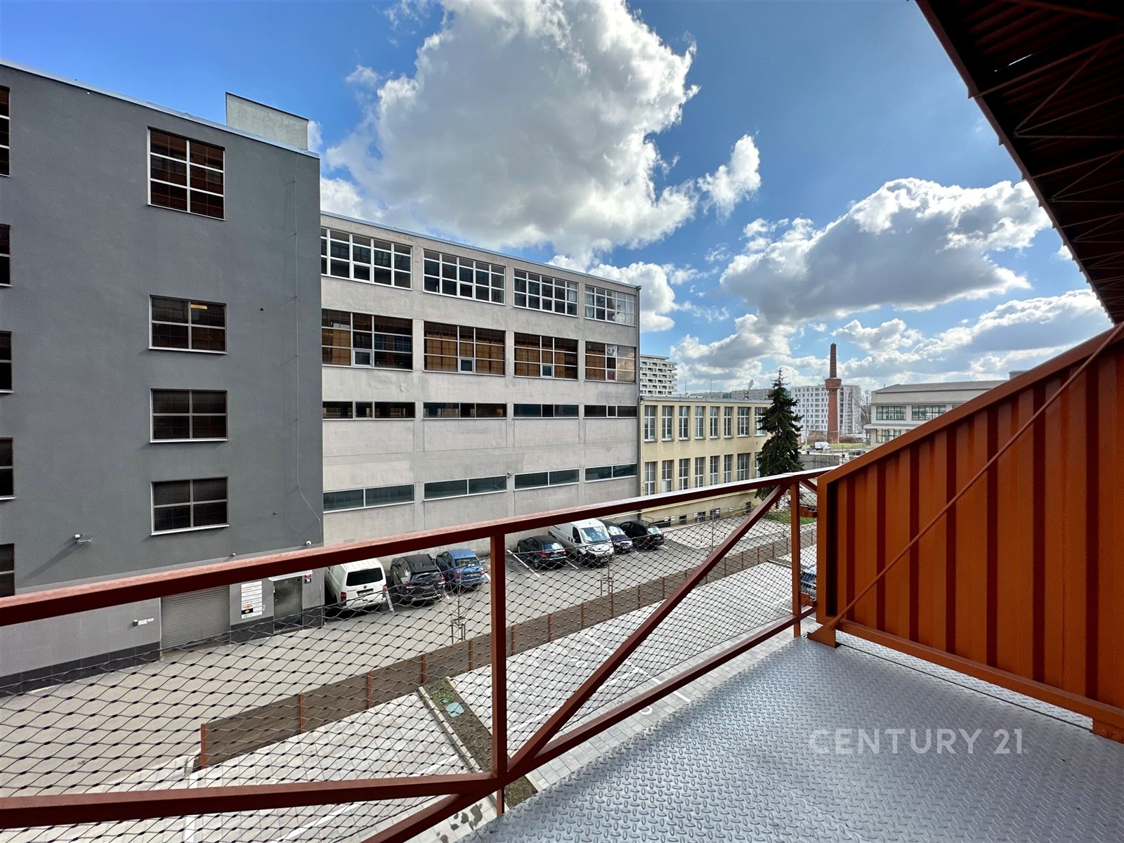 Malý balkon s kovovým zábradlím a výhledem na mode