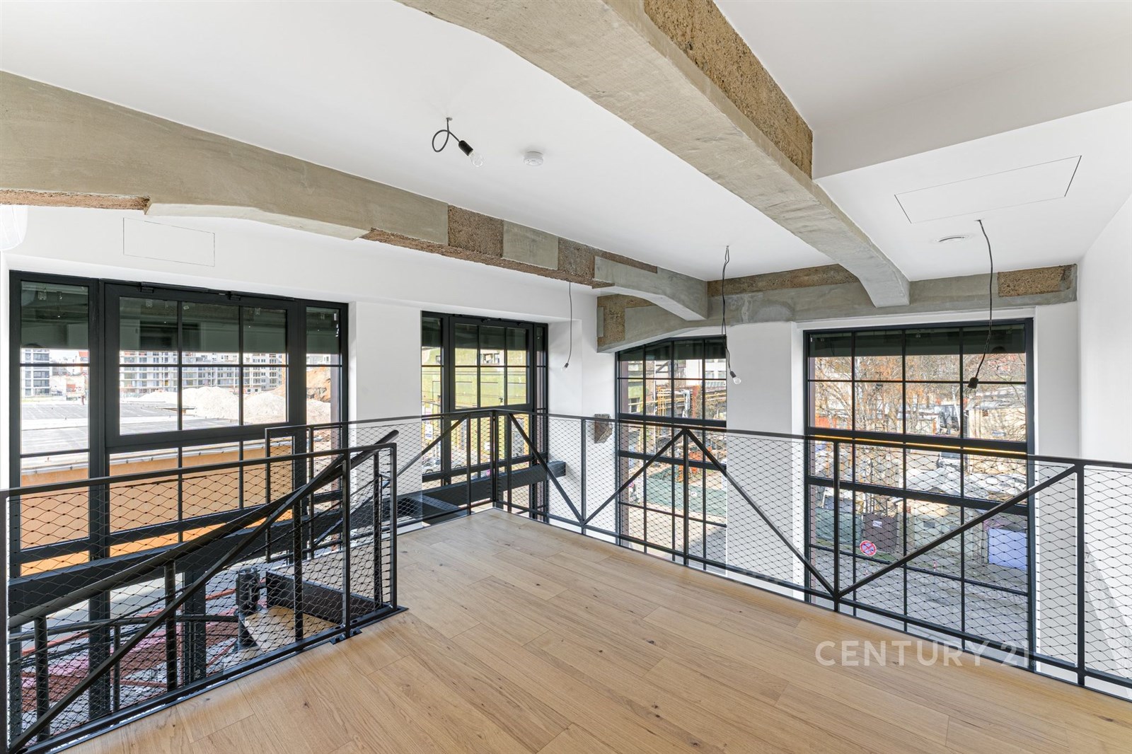 Světlá chodba s parketovou podlahou a velkými okny