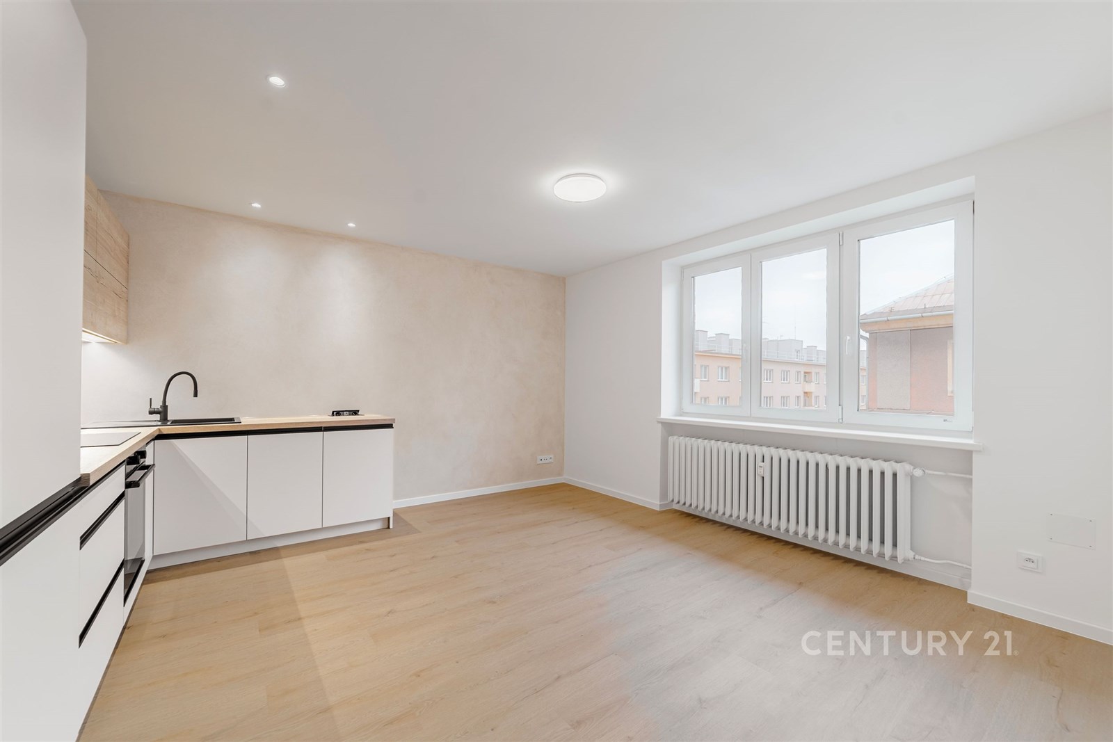 Světla kuchyň s moderními bílými skříňkami, parket