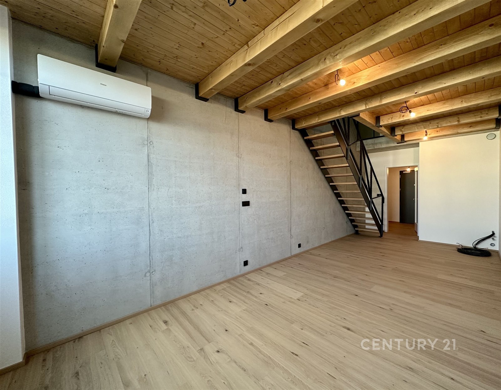 Obývací pokoj s dřevěným stropem a parketovou podlahou, moderní interiér, vestavěná klimatizace, schodiště do patra, betonové stěny