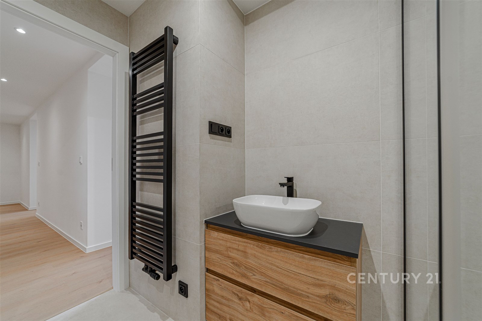 Koupelna s moderním umyvadlem, dřevěnou skříňkou a