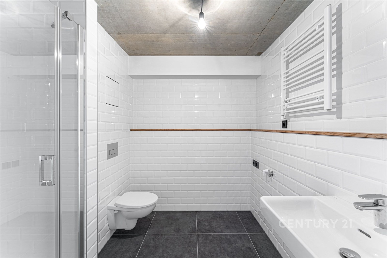 Moderní koupelna s bílými obklady, dlažbou a sprchovým koutem, minimalistický styl s černou dlažbou a stropním svítidlem, světlé provedení