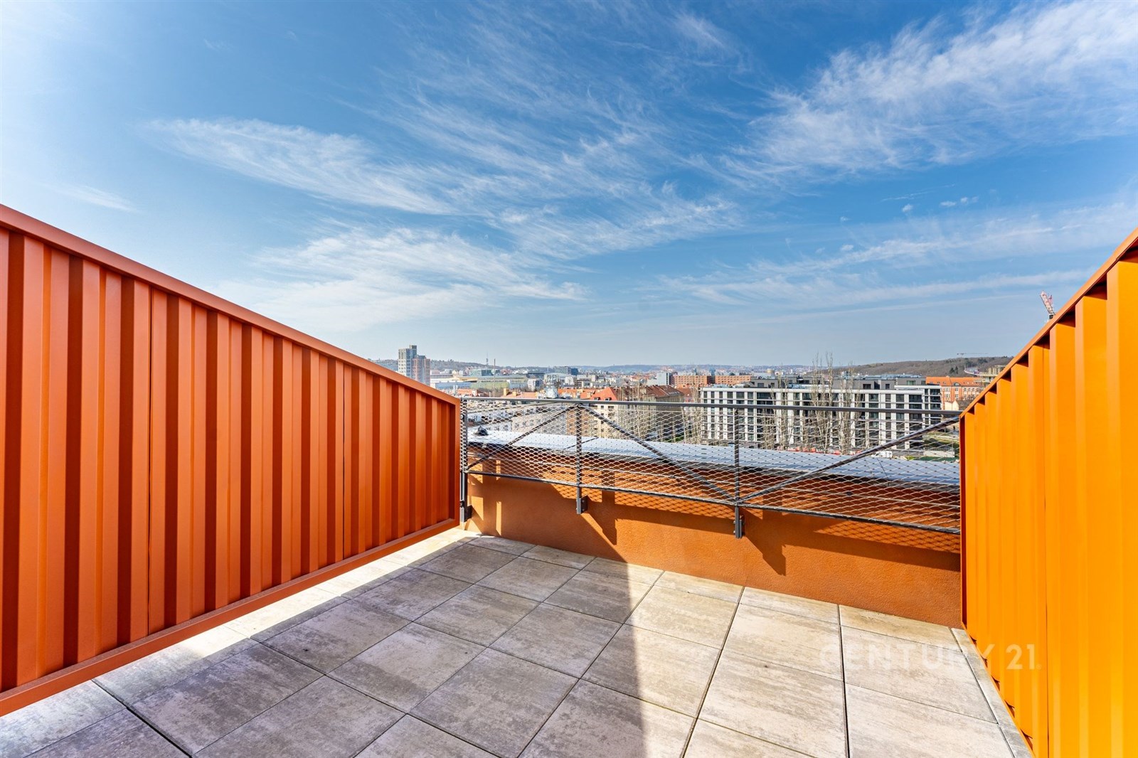 Terasa s dlažbou nabízí panoramatický výhled na město. Moderní zábradlí a otevřený prostor poskytují příjemné venkovní posezení.