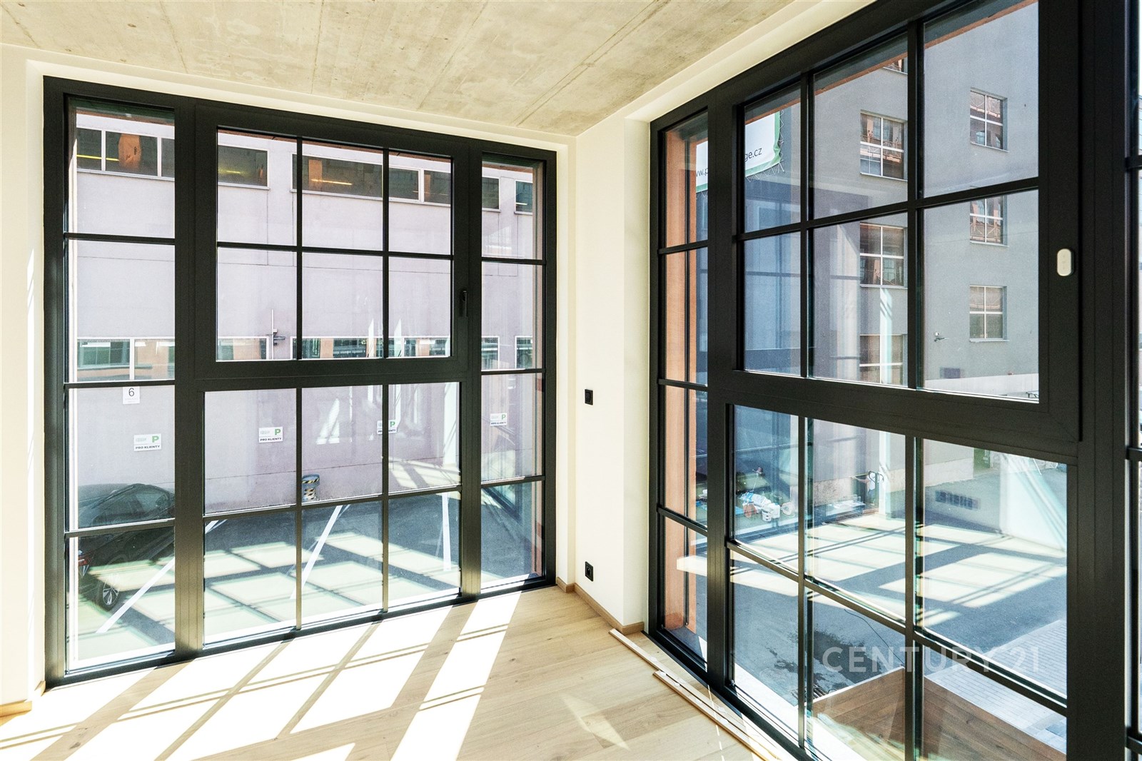 Světlý obývací pokoj s velkými okny, parketovou po