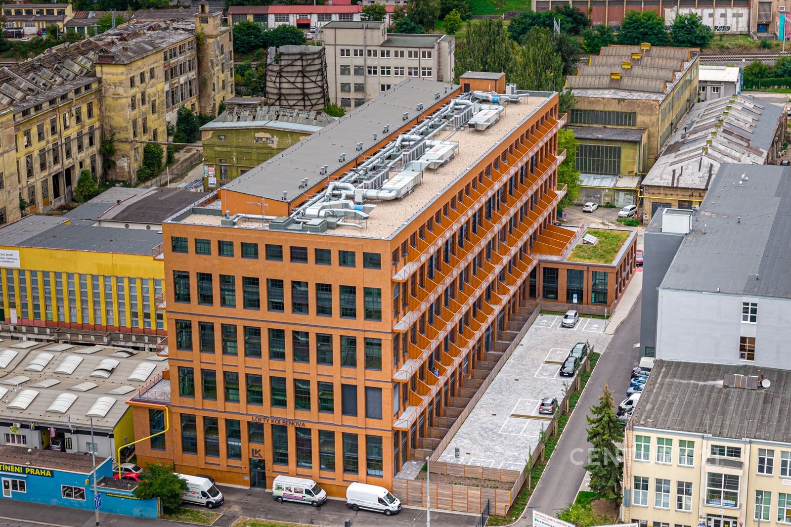 Průmyslová budova s oranžovou fasádou, nabízející 