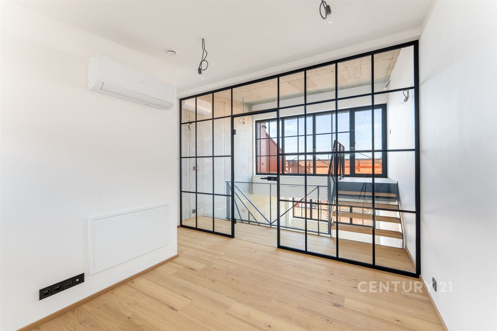 Světlý obývací pokoj s parketovou podlahou a velký