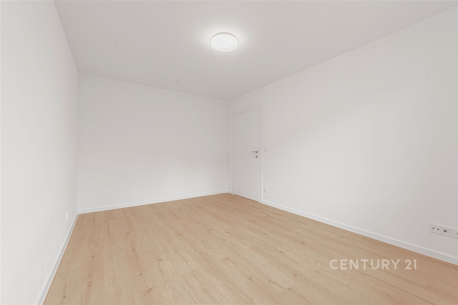 Světlý pokoj s parketovou podlahou, čisté bílé stě