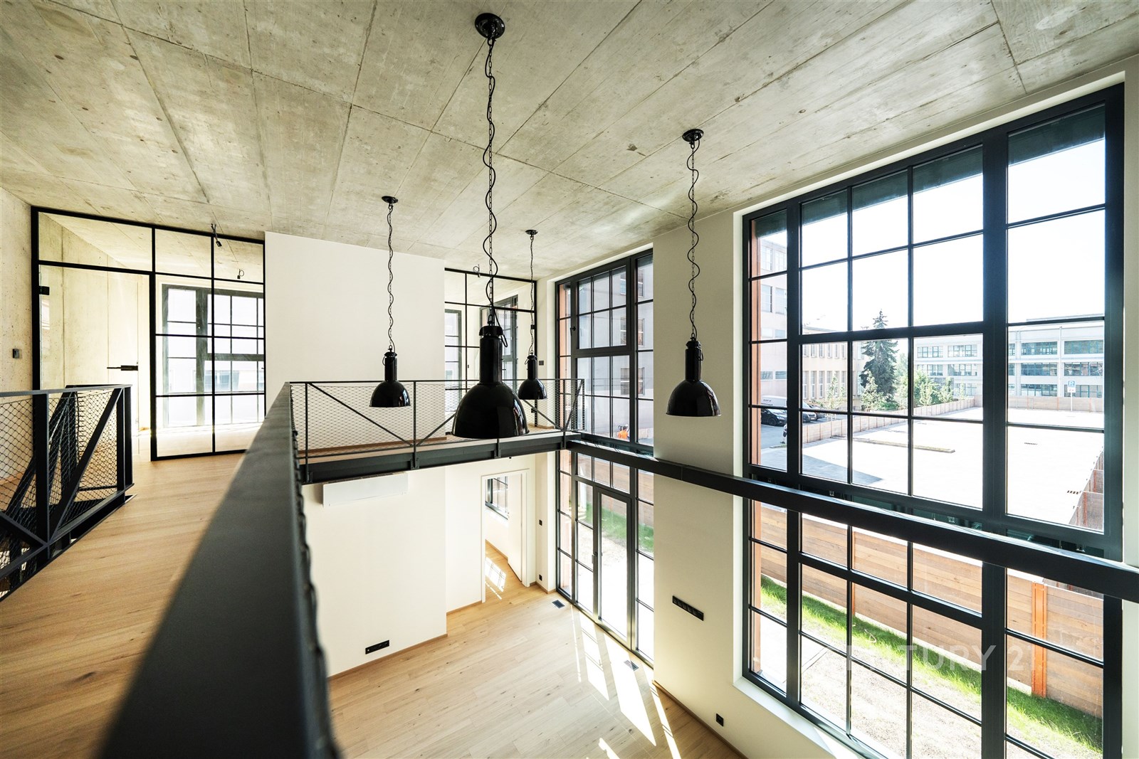 Světlý obývací pokoj s velkými okny, dřevěnou podl