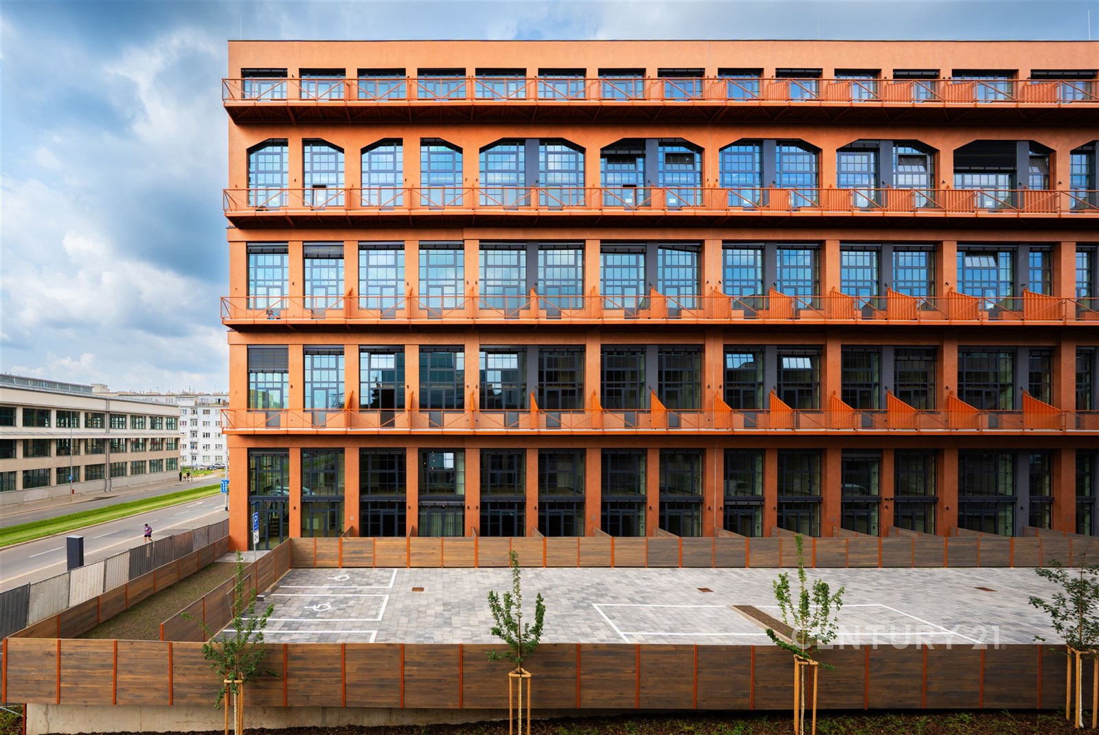 Industriální budova s moderním designem, velká okna na fasádě, cihlová konstrukce, nachází se v centru města