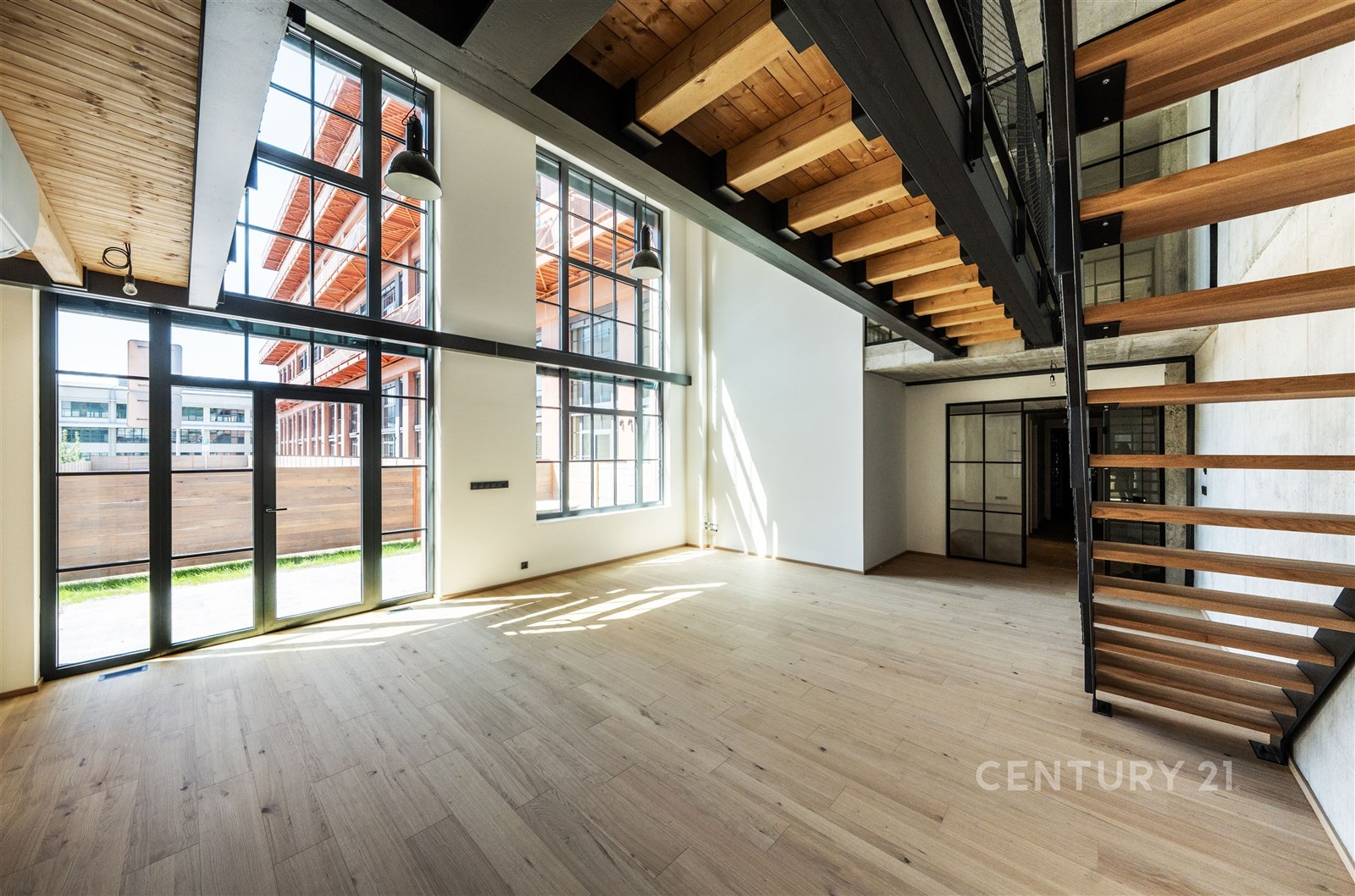 Světlý obývací pokoj s velkými okny, dřevěnými str