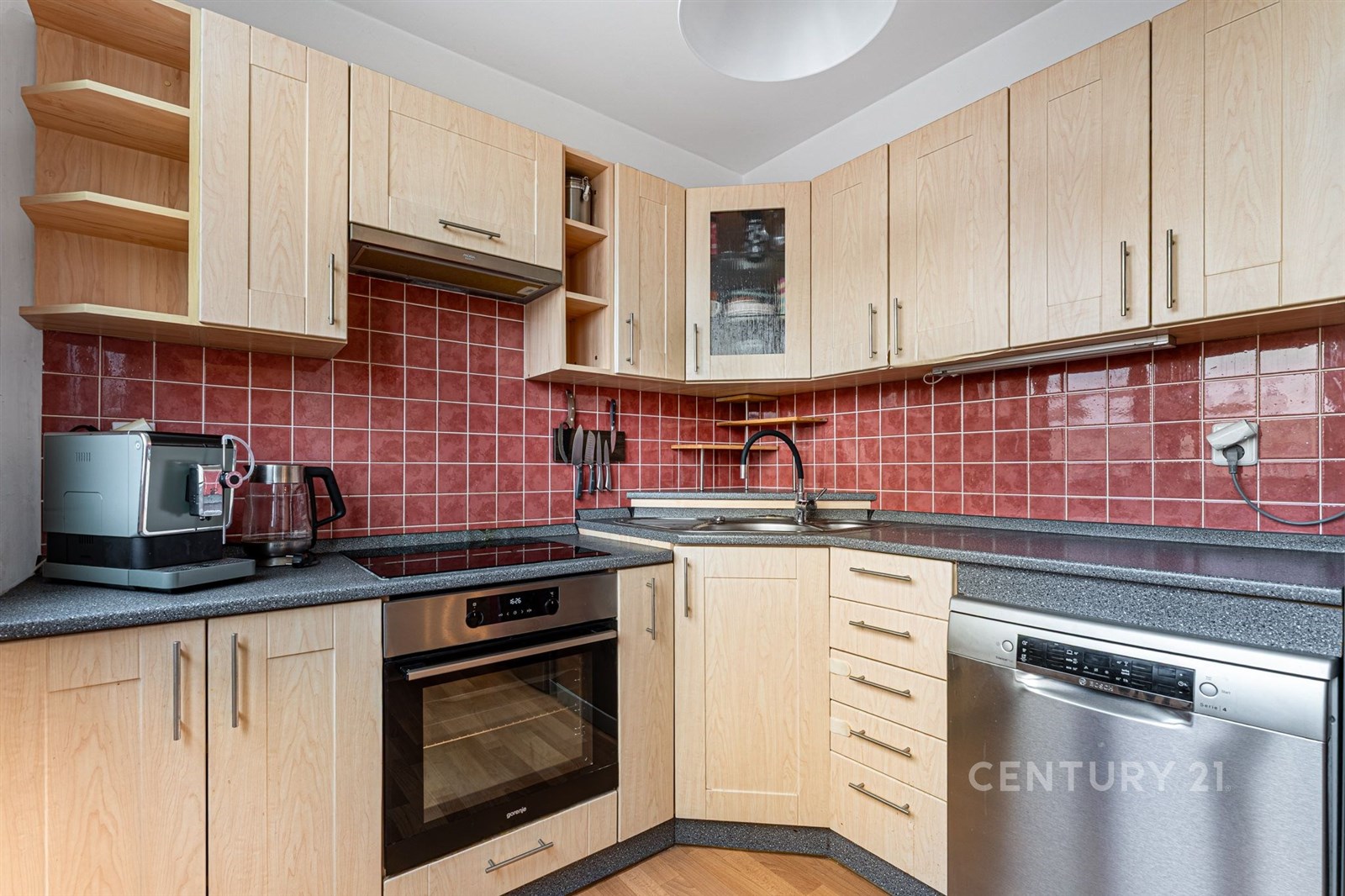 Moderní kuchyň s dřevěnými skříňkami, červenými ob