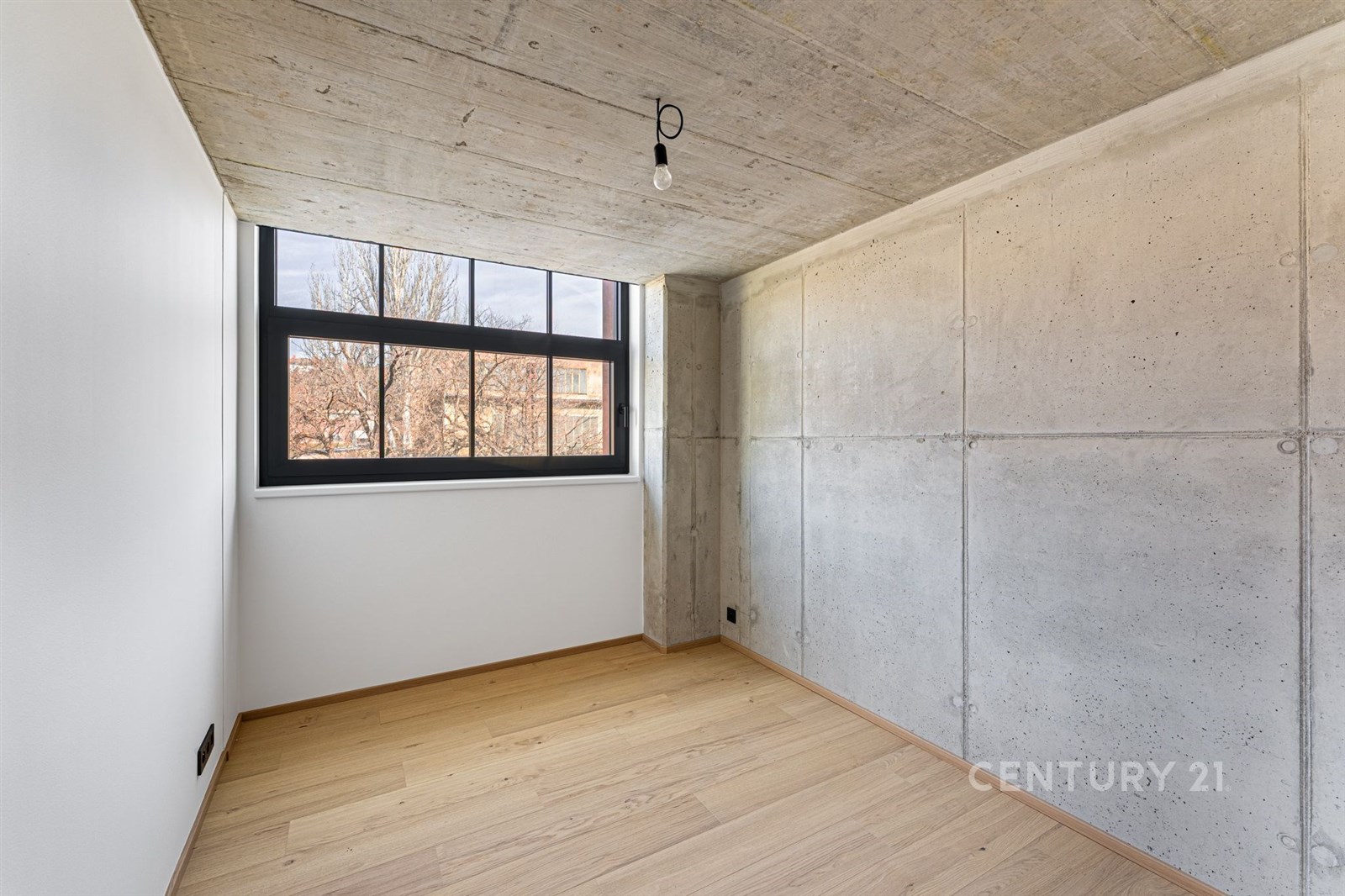 Ložnice s parketovou podlahou, betonovými stěnami 