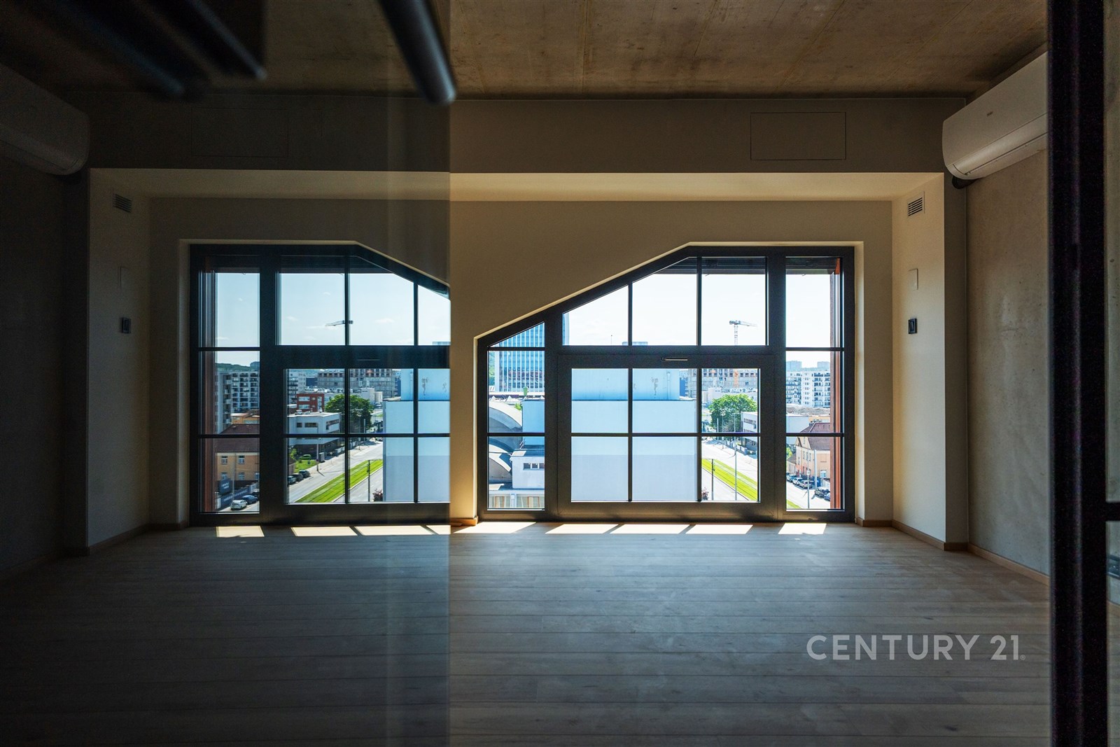 Prázdný obývací pokoj s velkými okny, parketovou p