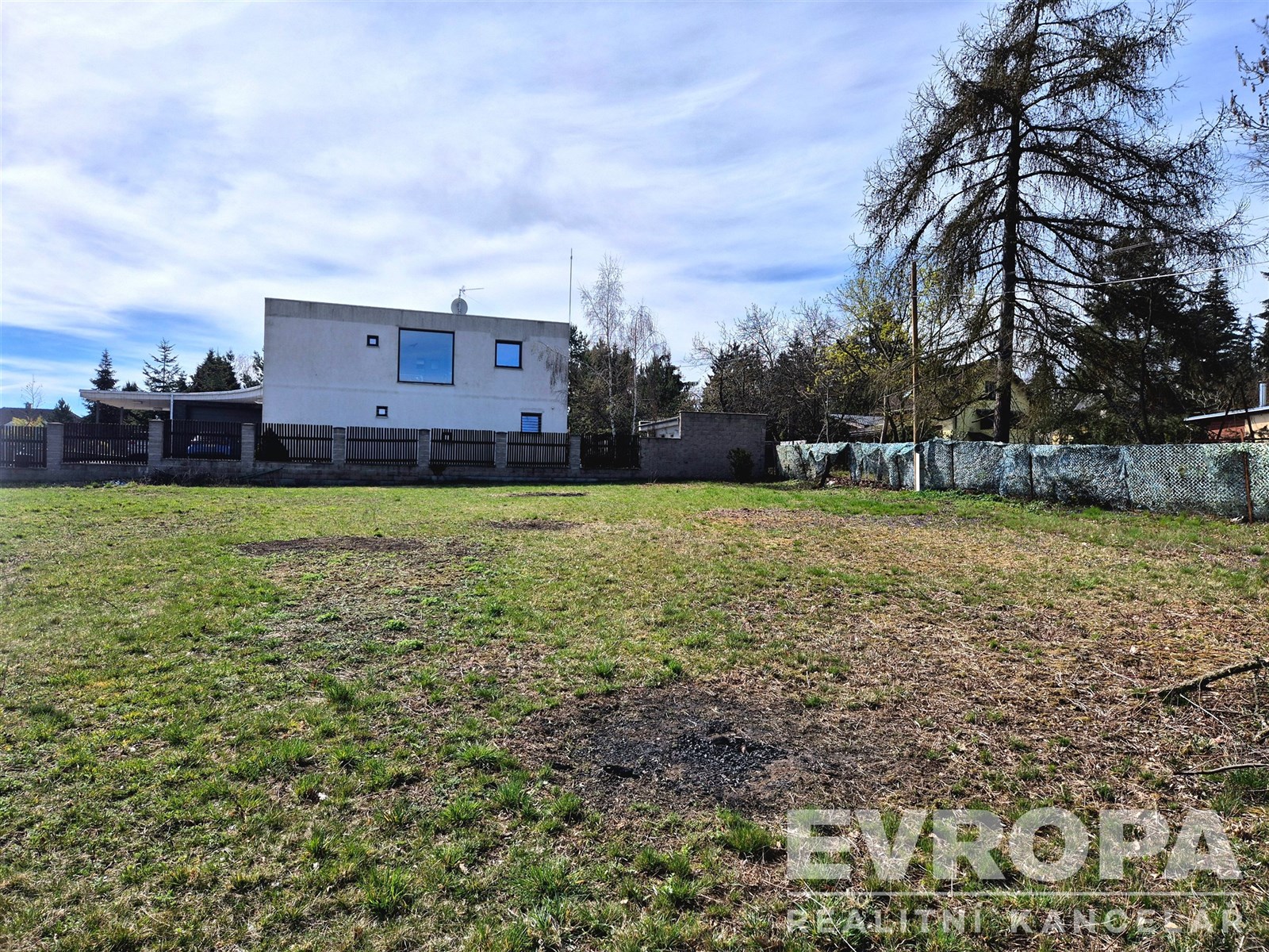 Prázdný stavební pozemek s travnatým povrchem, ide