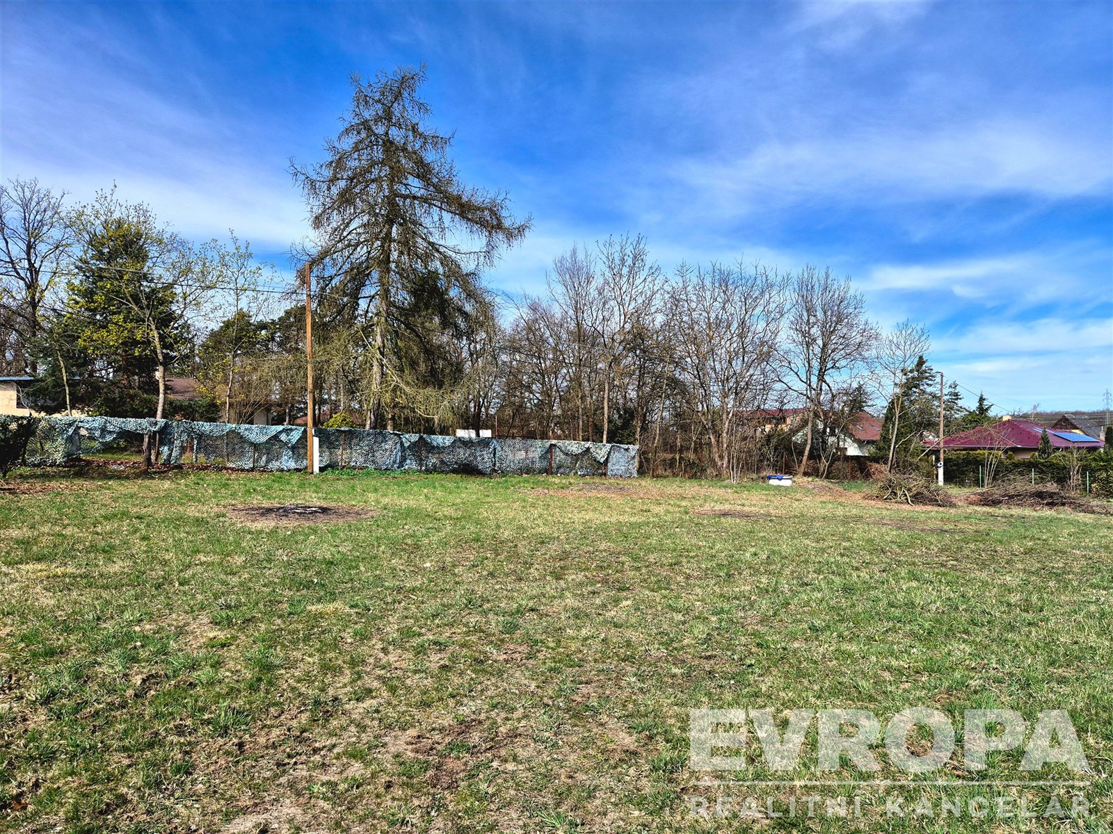 Pozemek s travnatým povrchem, vhodný pro stavbu, o