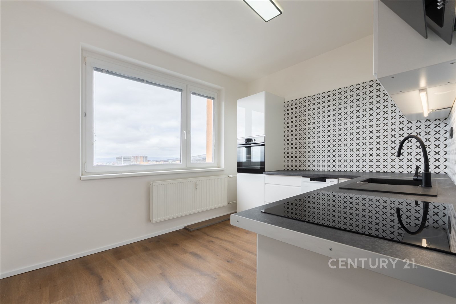 Moderní kuchyň s parketovou podlahou, velkým oknem